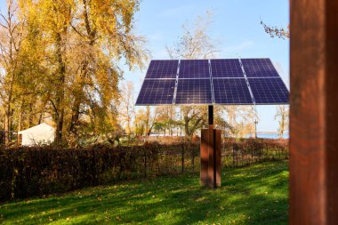Güneşli bir günde parktaki güneş panelleri. Güzel bir sonbahar günü. Çevre koruma konsepti fotoğrafı. Yatay görüntü. Sarı sıcak eğim.