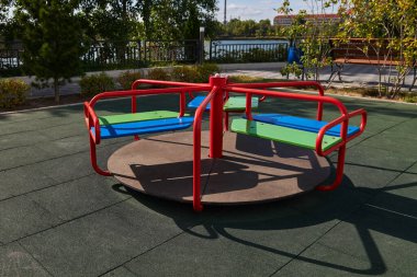 Çocuk parkında koronavirüs salgını sırasında boş renkli bir atlıkarınca. Güneşli bir gün. Covid-19 tecrit. Güneşli bir gün.