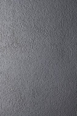 Gri mat taş duvar dokusu. Gri renklerle boyanmış olaysız yüzey. Arkaplanda usulsüzlük ve rahatlama var. Dikey fotoğraf.