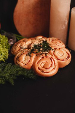 Siyah arka planda sarımsaklı ve dereotlu taze ekmek rulosu.. 