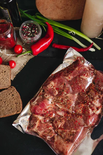 Meat in an vacuum bag on the kitchen table. Beef steak vacuum sealed ready for sous vide cooking on kitchen table.