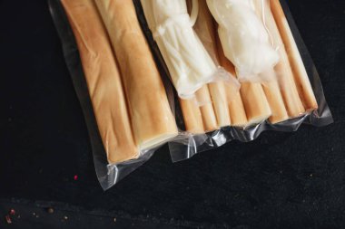 Siyah arka planda füme peynir. Süpürge peyniri paketleri.