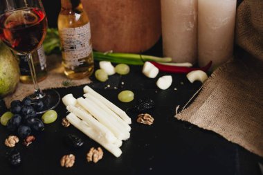 Üzümlü, cevizli ve siyah arkaplanlı erikli tel peynir. Suluguni peyniri.. 