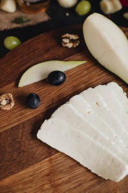 Tahtada armut ve üzümle dilimlenmiş peynir.. 