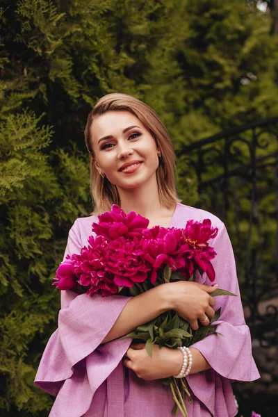 Feliz Mujer Sonriente Vestido Lino Rosa Sostiene Peonías Rosas Las — Foto de Stock