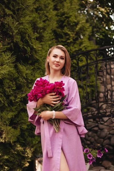 Uma Bela Jovem Mulher Vestido Linho Rosa Segura Peônias Rosa — Fotografia de Stock