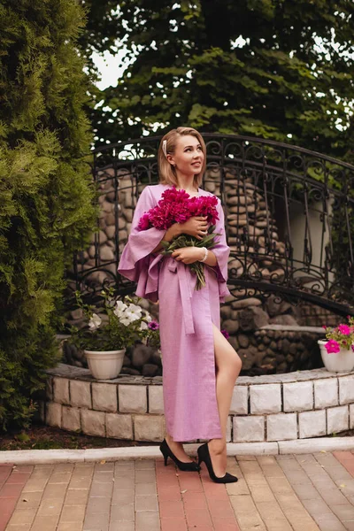 Uma Bela Jovem Mulher Vestido Linho Rosa Segura Peônias Rosa — Fotografia de Stock