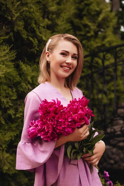 Donna Felice Sorridente Abito Lino Rosa Tiene Peonie Rosa Mano — Foto Stock