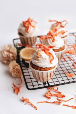 Beyaz arka planda siyah metal bir askıda kremalı havuçlu kek. Tatlı hamur işleri. Havuçlu kek..