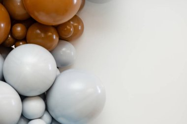 Bej ve gri tonlarda minimalist balon dekorasyonu, pürüzsüz parlak yüzeyler ve temiz beyaz arka plan. Metin ya da tasarım ögeleri için mükemmel geniş düzen.