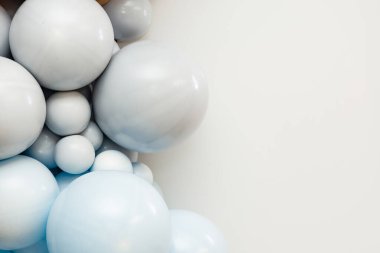 Minimalist balon düzenleme. Temiz bir arka planda yumuşak mavi ve beyaz küreler. Modern festival dekorasyonu, havadar kompozisyon, kopyalama alanı.