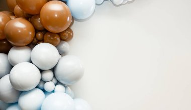 Temiz beyaz arka planda kahverengi, mavi ve beyaz balonları olan renkli balon çelenkleri. Metin için alanı olan minimalist parti dekorasyonu.