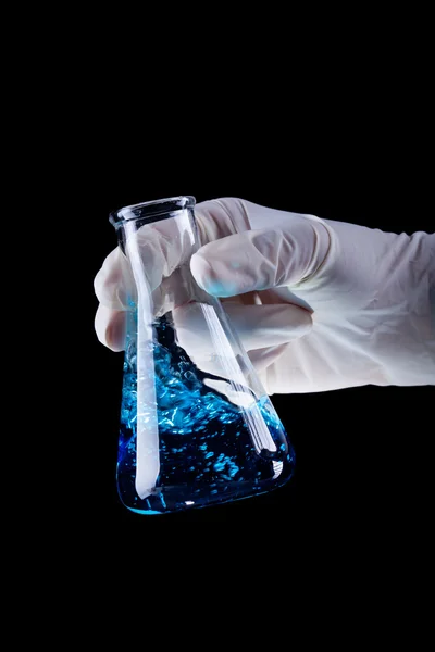 Hand holding chemical flask stirring blue liquid — Stock Photo, Image