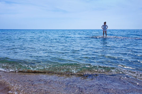 Woman standing in the shallow waters of the sea — Stock Photo, Image