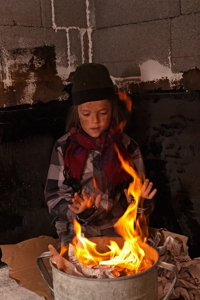 在火变暖的脏无家可归的男孩 — 图库照片