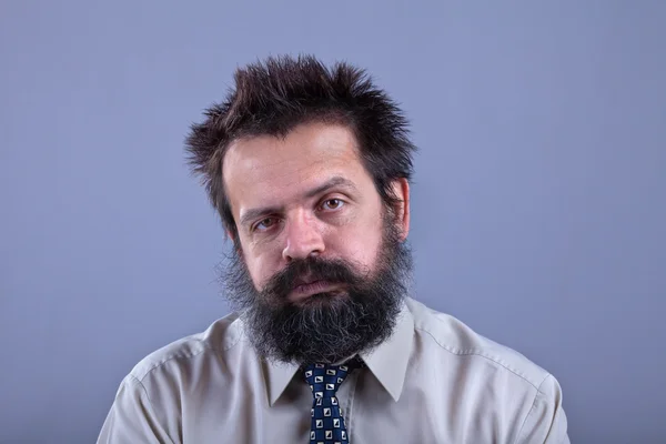 Уставший мужчина с кустистыми волосами и бородой — стоковое фото