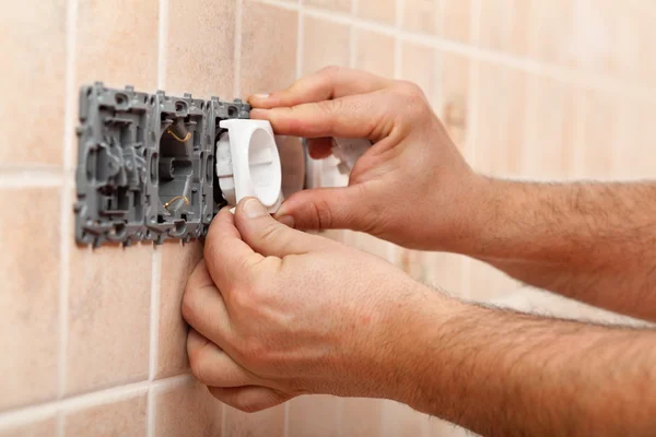 Electrician hands installing electrical wall fixture — Stock Photo, Image