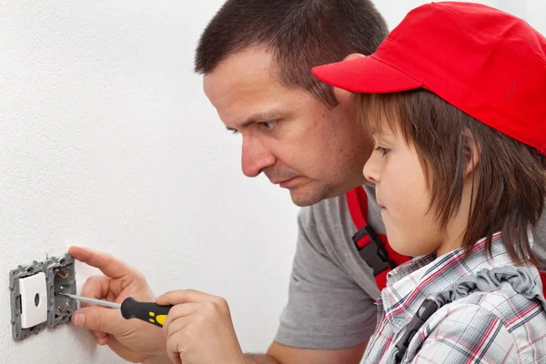 Jongen leren hoe te repareren van een elektrische wand armatuur — Stockfoto