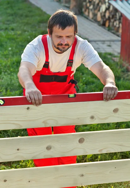 Hombre construyendo nueva valla de madera — Foto de Stock