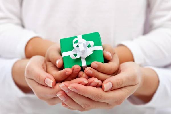 Dare un regalo - mani bambino e donna con confezione regalo — Foto Stock