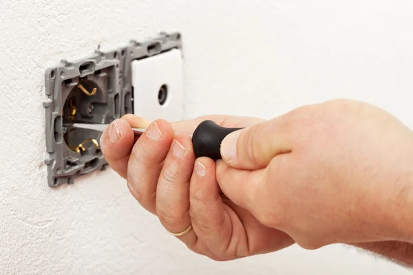 Eletricista mão montagem de um dispositivo elétrico de parede — Fotografia de Stock