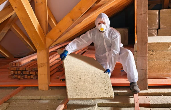 Hombre con panel de lana de roca instalando capa de aislamiento — Foto de Stock