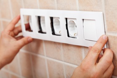 Dekoratif çerçeve üzerinde elektrik soketleri yükleme eller