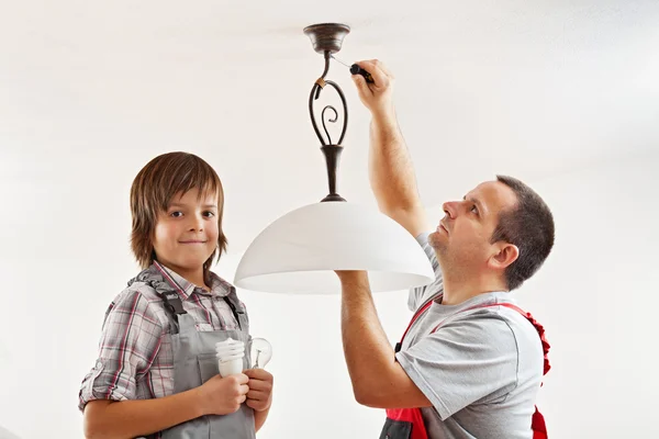 Changing the incandescent lightbulb with a fluorescent one — Stock Photo, Image