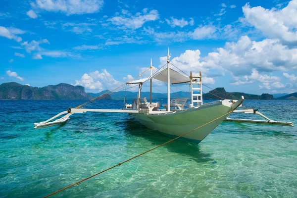 Белая деревянная лодка в чистой морской воде — стоковое фото