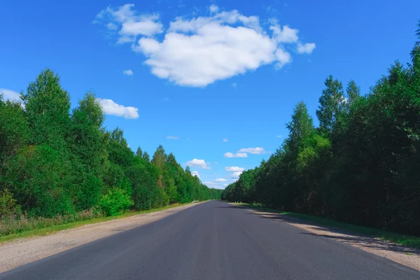 Carretera vacía, bosque verde y nubes —  Fotos de Stock