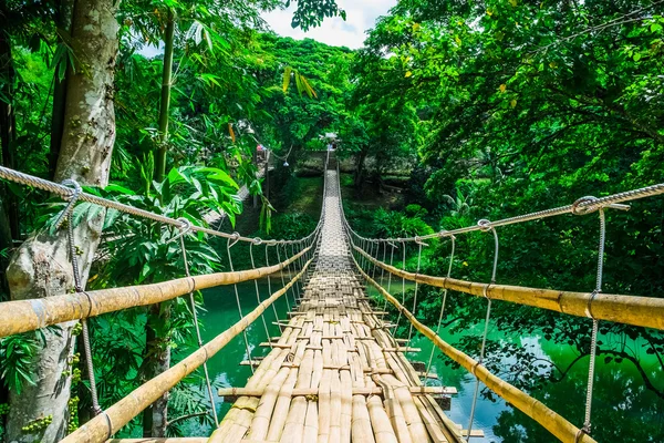 Puente colgante peatonal de bambú sobre río — Foto de Stock