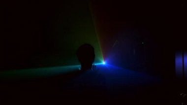 Aydınlık arka planda, karanlıkta hareket eden farklı renkte genç bir kızın görüntüsü. Projektör.