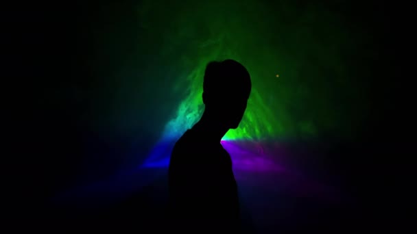 사진 : Young Man on Light Background Of Different Colors Moving In The Dark. 다른 색깔의 삼중도에 있었을 때와 같이 그의 등을 돌렸던 남자. — 비디오