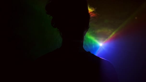 Bild av ung flicka på ljus bakgrund av olika färger rör sig i mörkret. — Stockvideo