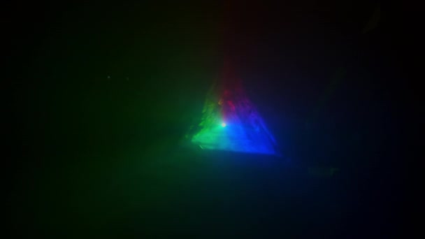 概要異なる色の光を作成します。暗闇と煙の中で動く光線を再生することによって作成された三角形. — ストック動画