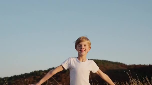 Little Boy Runs Field met droog gras. — Stockvideo