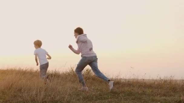 Férias em família na natureza. Mãe e filho brincando com a bola — Vídeo de Stock