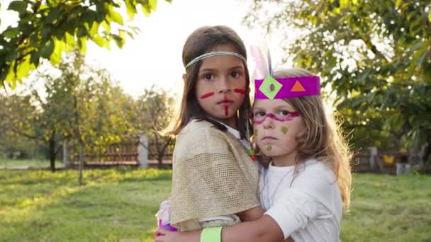 Twee kleine meisjes in Indiase kostuums staan knuffelen elkaar. — Stockvideo