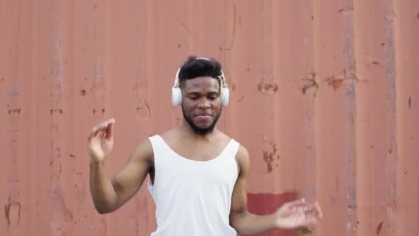 Fiatal fekete srác táncol az utcán fülhallgatóban. — Stock videók
