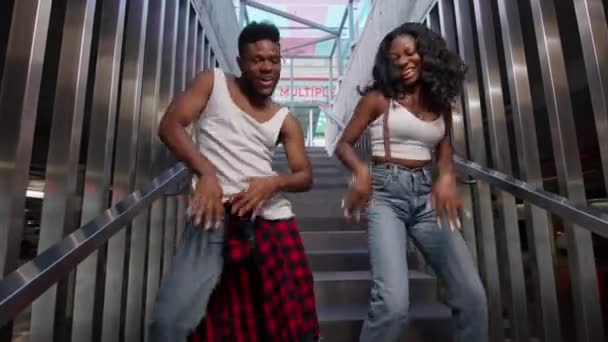 Уличные танцы. Молодая пара танцует на лестнице. Cheerful Black Guy and Girl Dancing Modern Dance. — стоковое видео