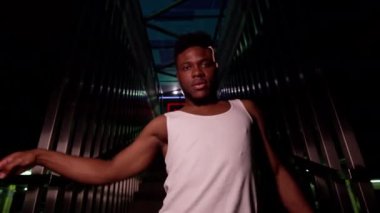 Genç siyahi adam merdivenlerde dans ediyor. Ritmik bir şekilde hareket ediyor. İyi akşamlar..