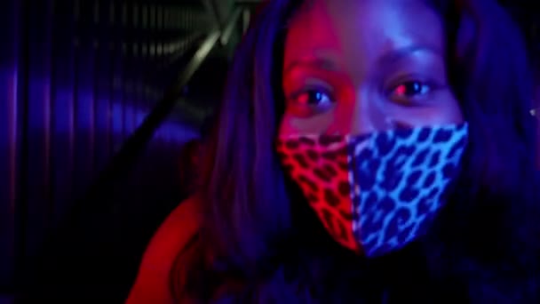 Porträt der schönen schwarzen Mädchen in Maske zum Schutz vor Viren. Sie tanzt. — Stockvideo