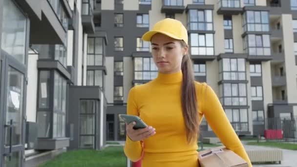 Girl Delivery Service Worker Comes To The Door And Throws Box. She Looks At Her Phone And Throws The Box To The Ground From The Height. — Stock Video