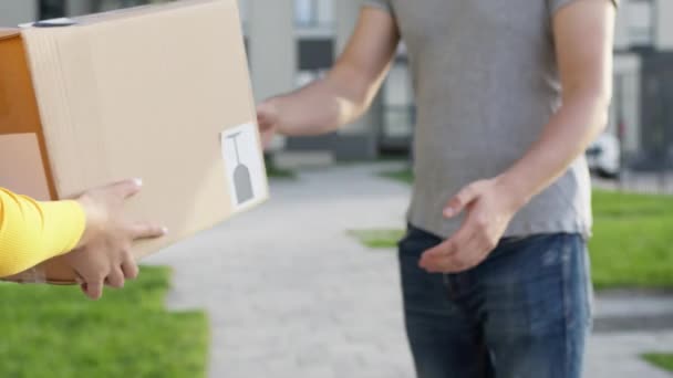 Reunión en la calle chica entrega trabajador y cliente. Guy guarda el pedido recibido en caja. Cara invisible. — Vídeos de Stock