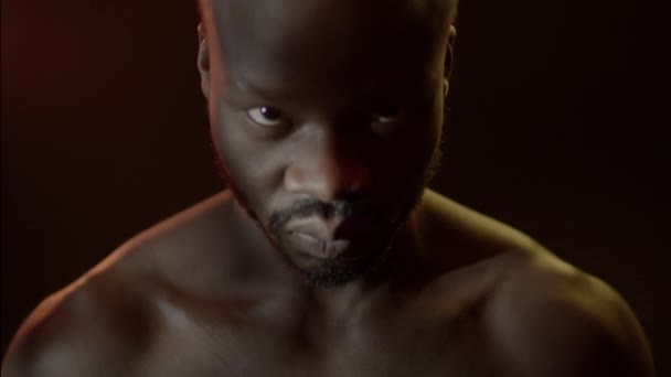 Πορτρέτο του νεαρού μαύρου άντρα με γυμνό Torso στο σκοτεινό δωμάτιο. — Αρχείο Βίντεο