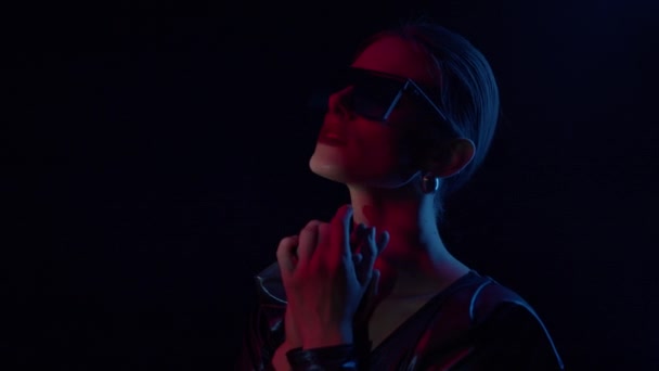 Mystisk flicka i solglasögon i mörka rummet. — Stockvideo