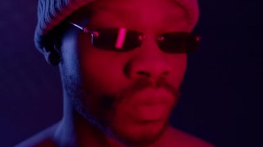 Siyah adam karanlık odada güneş gözlüklü ve şapkalı..