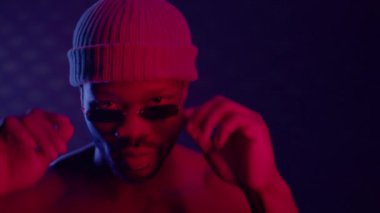 Siyah adam karanlık odada güneş gözlüklü ve şapkalı..