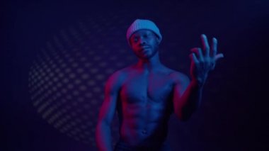 Mavi ışıklandırmayla bağlantılı çıplak gövdeli siyah adam..