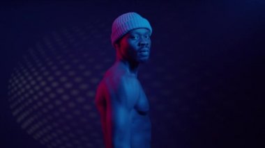 Mavi ışıklandırmayla bağlantılı çıplak gövdeli siyah adam..